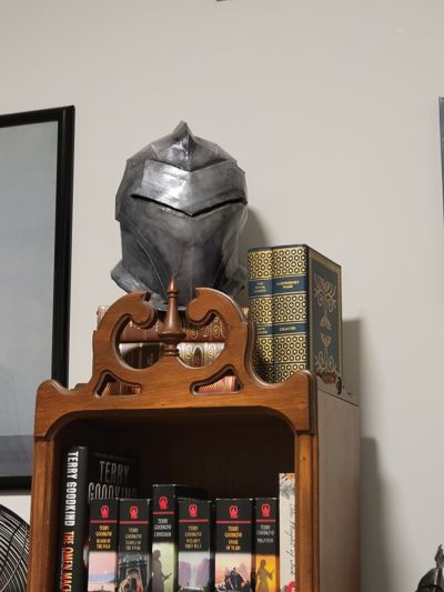 Helmet on display on bookshelf.