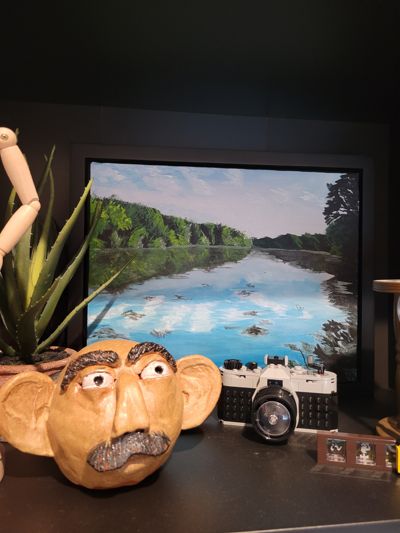 Framed painting on shelf.